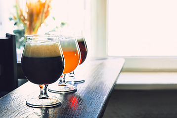 Image showing Glasses of different kinds of beer on wooden background