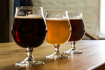 Image showing Glasses of different kinds of beer on wooden background