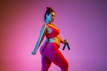 Image showing Young caucasian plus size female model\'s training on gradient background