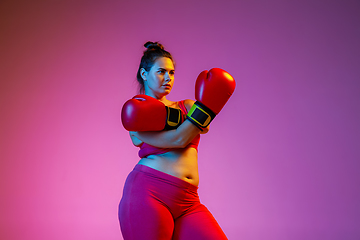 Image showing Young caucasian plus size female model\'s training on gradient background