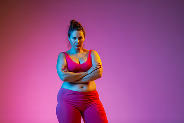 Image showing Young caucasian plus size female model\'s training on gradient background