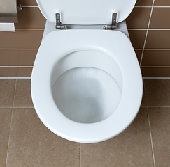 Image showing White toilet bowl in the bathroom, flushing