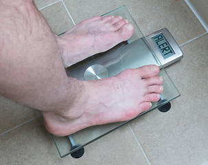 Image showing Man\'s feet on weight scale - Alert