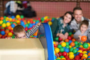 Image showing parents and kids playing in the pool with colorful balls