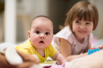 Image showing little sister and her baby brother playing at home
