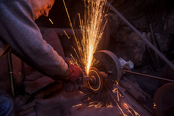 Image showing the blacksmith polishing metal products