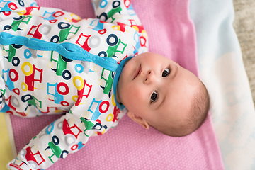 Image showing top view of newborn baby boy lying on colorful blankets