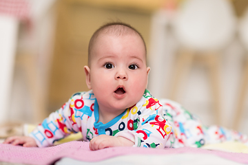 Image showing newborn baby boy playing on the floor