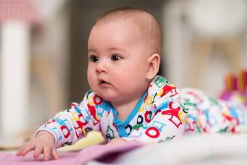 Image showing newborn baby boy playing on the floor