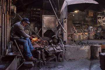 Image showing the blacksmith polishing metal products