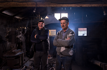 Image showing portrait of two generations confident blacksmith