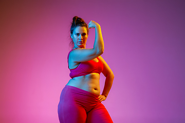 Image showing Young caucasian plus size female model\'s training on gradient background