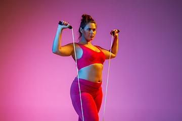 Image showing Young caucasian plus size female model\'s training on gradient background