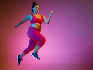 Image showing Young caucasian plus size female model\'s training on gradient background