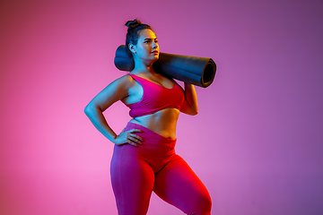 Image showing Young caucasian plus size female model\'s training on gradient background