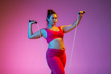 Image showing Young caucasian plus size female model\'s training on gradient background