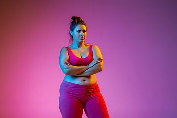 Image showing Young caucasian plus size female model\'s training on gradient background