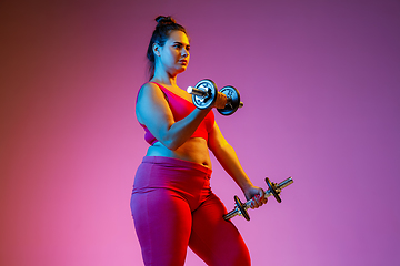 Image showing Young caucasian plus size female model\'s training on gradient background