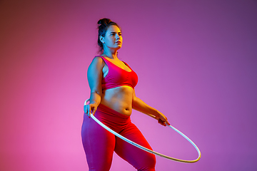 Image showing Young caucasian plus size female model\'s training on gradient background