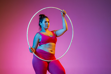 Image showing Young caucasian plus size female model\'s training on gradient background