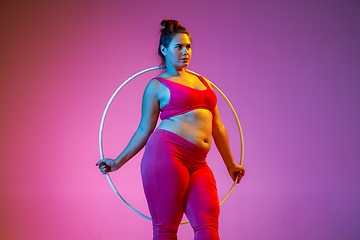 Image showing Young caucasian plus size female model\'s training on gradient background