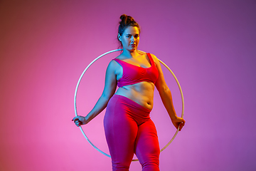 Image showing Young caucasian plus size female model\'s training on gradient background