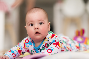 Image showing newborn baby boy playing on the floor