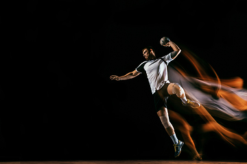 Image showing Young handball player against dark studio background in mixed light