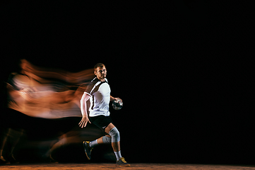 Image showing Young handball player against dark studio background in mixed light