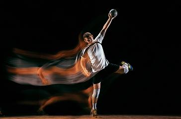 Image showing Young handball player against dark studio background in mixed light