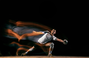 Image showing Young handball player against dark studio background in mixed light