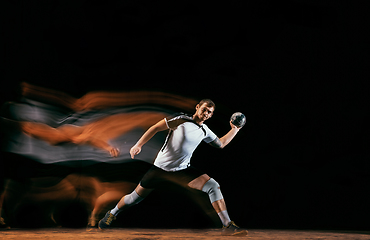 Image showing Young handball player against dark studio background in mixed light