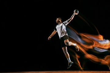 Image showing Young handball player against dark studio background in mixed light