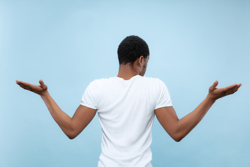 Image showing Half-length close up portrait of young man on blue background.