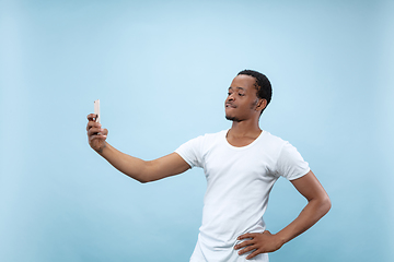 Image showing Half-length close up portrait of young man on blue background.