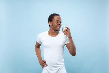 Image showing Half-length close up portrait of young man on blue background.