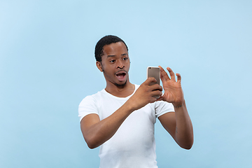 Image showing Half-length close up portrait of young man on blue background.