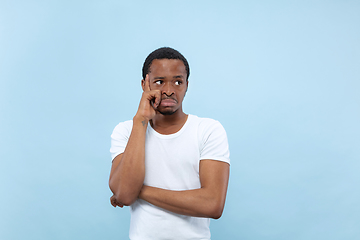 Image showing Half-length close up portrait of young man on blue background.