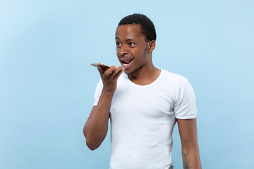 Image showing Half-length close up portrait of young man on blue background.