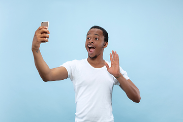 Image showing Half-length close up portrait of young man on blue background.