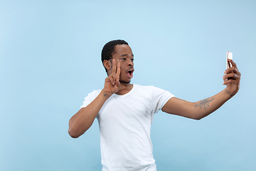 Image showing Half-length close up portrait of young man on blue background.