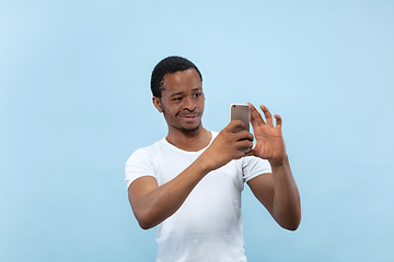 Image showing Half-length close up portrait of young man on blue background.