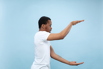 Image showing Half-length close up portrait of young man on blue background.