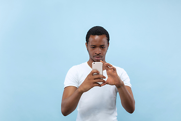 Image showing Half-length close up portrait of young man on blue background.