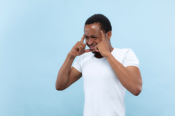 Image showing Half-length close up portrait of young man on blue background.