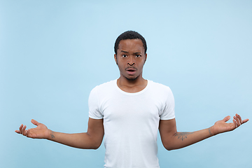 Image showing Half-length close up portrait of young man on blue background.