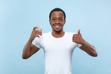 Image showing Half-length close up portrait of young man on blue background.