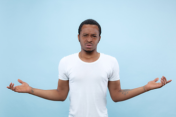 Image showing Half-length close up portrait of young man on blue background.