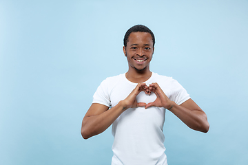 Image showing Half-length close up portrait of young man on blue background.