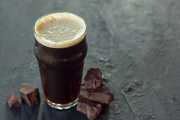 Image showing Glass of dark beer on the stone table background